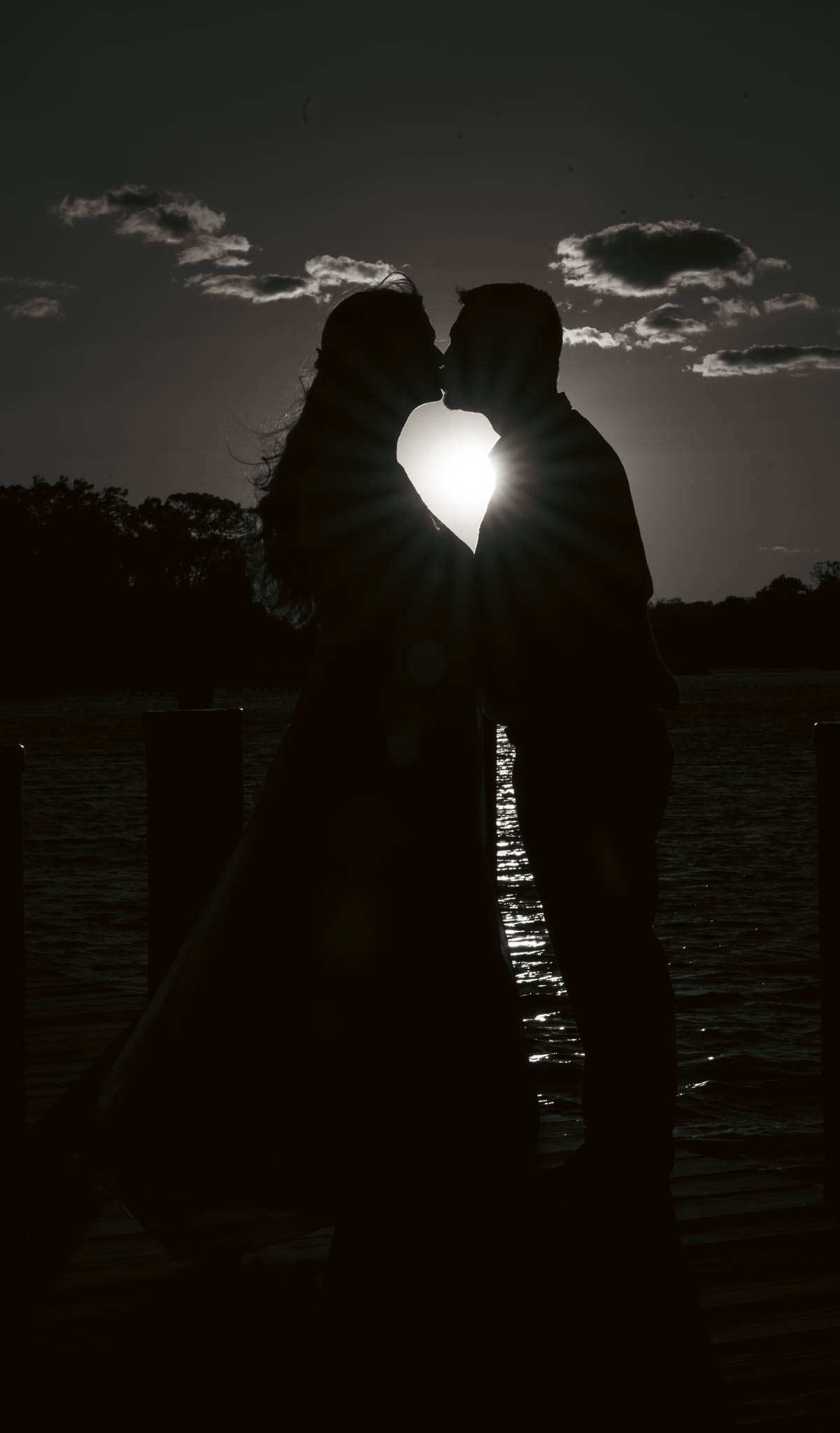 A silhouetted kiss against the setting sun over the creek — backyard wedding in Annapolis, Maryland